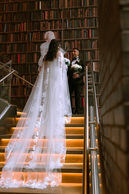 Cathedral-length veil spilling down a wooden staircase