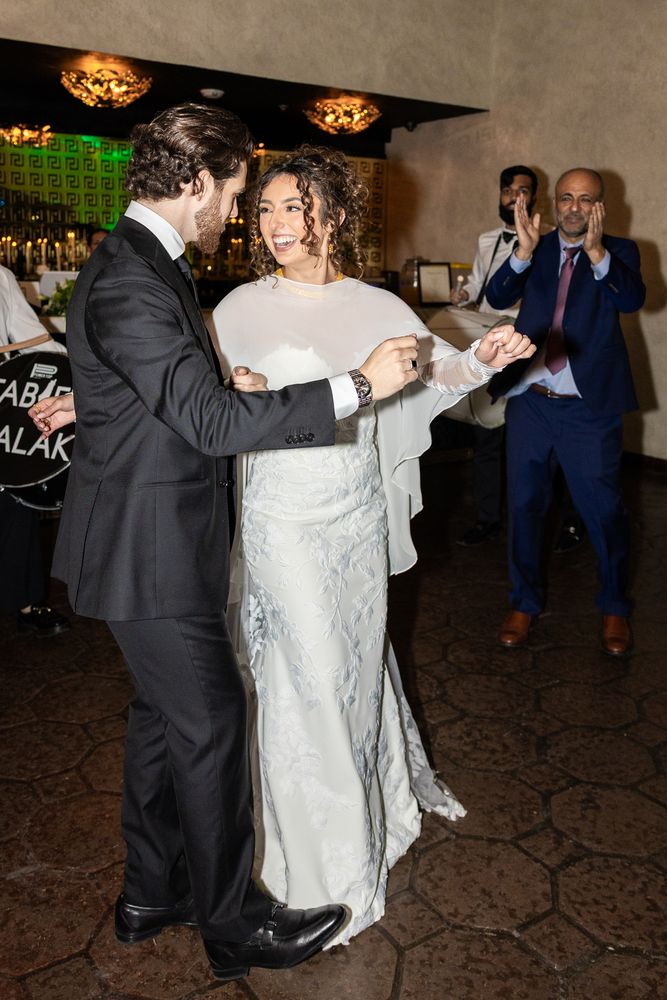 The couple dance together in the middle of the room