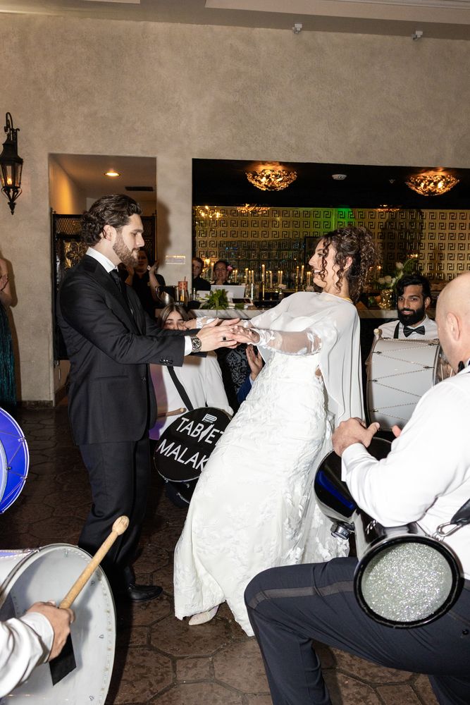 The couple dance beside the drummers at the edge of the floor