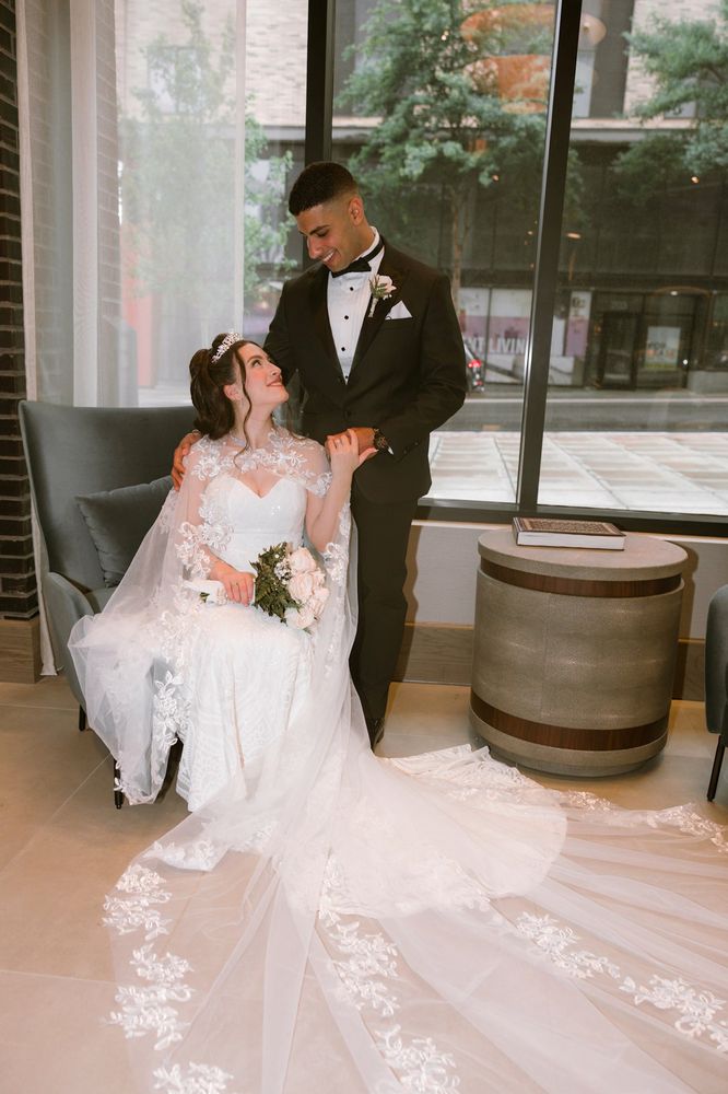 Groom dipping the bride into a kiss beside a window