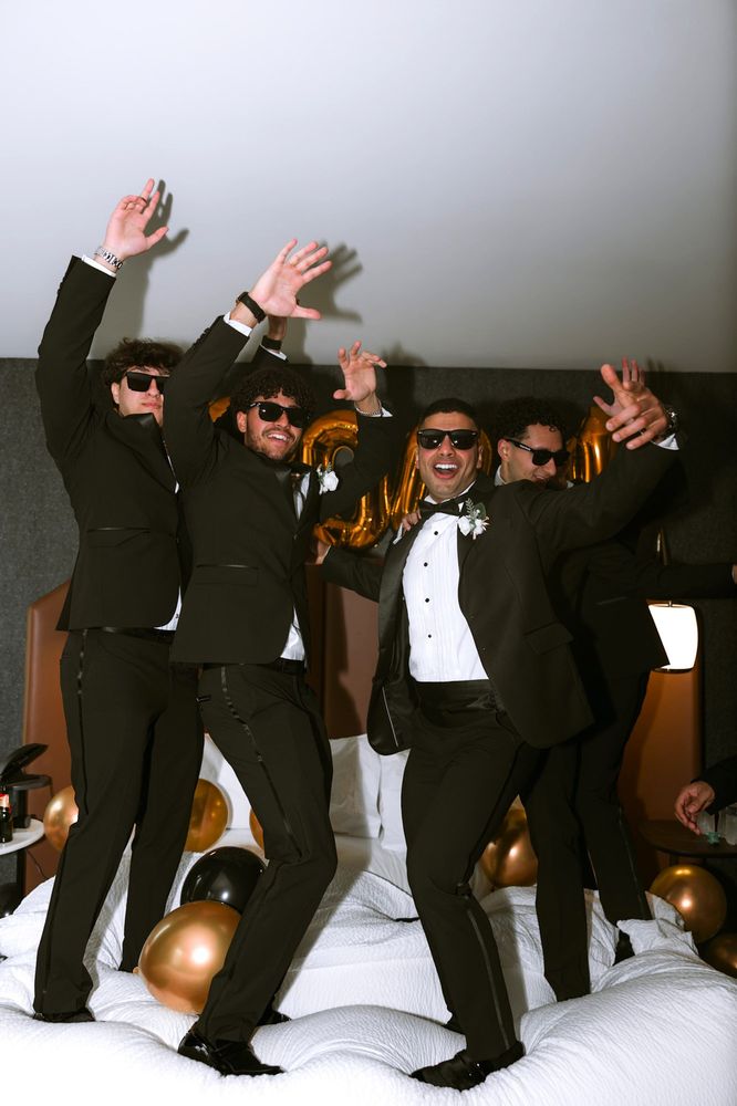 Groomsmen in sunglasses jumping and cheering together