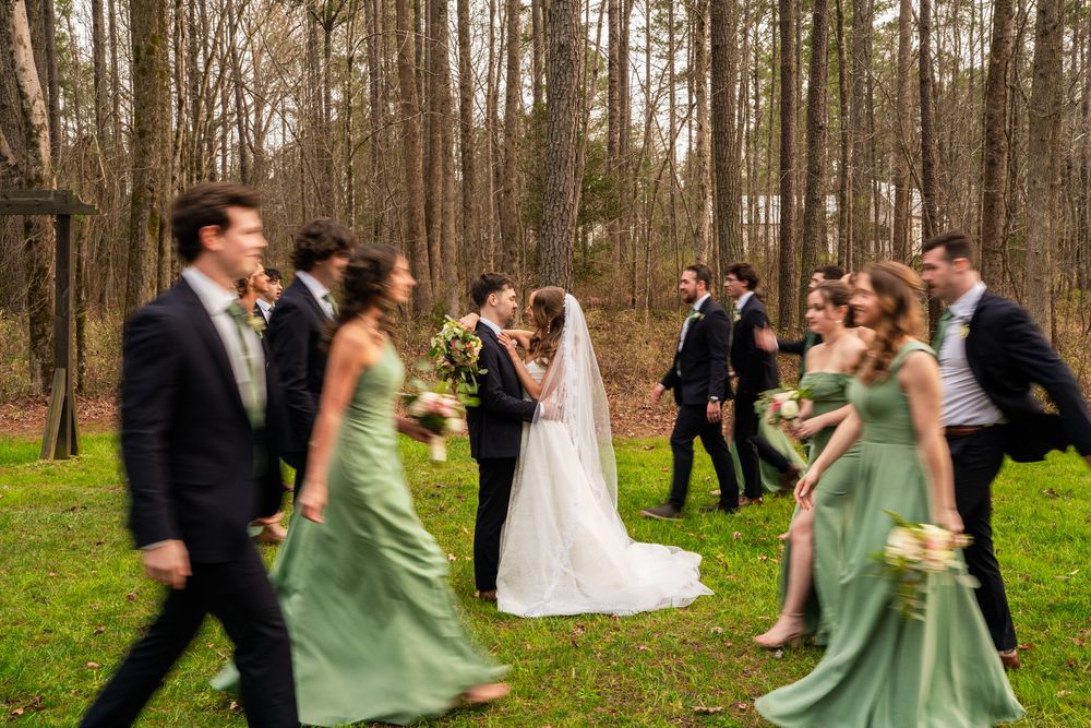 The wedding party walking together through the trees