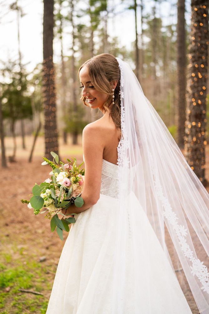 The bride looking back over her shoulder, veil trailing behind her