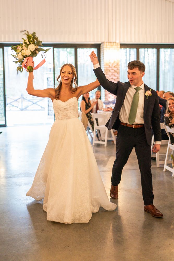 The couple entering the reception with their arms raised