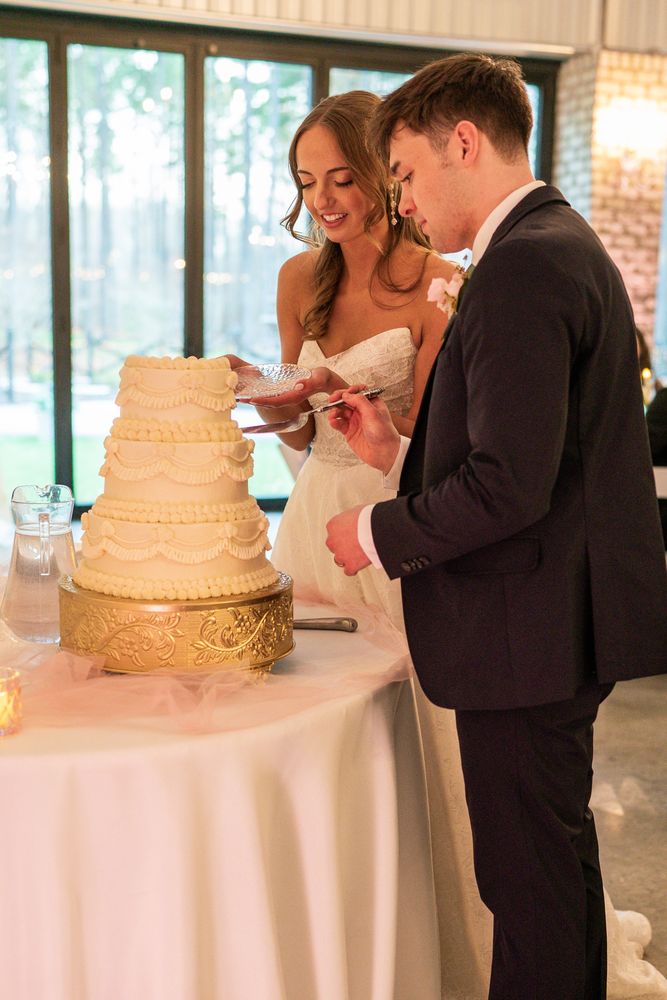 The couple cutting a gold-tiered wedding cake