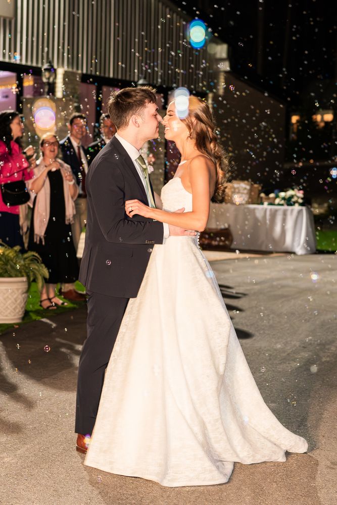 The couple dancing in falling confetti under the lights